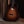 Acoustic guitar leaning against a wooden wall with a dark background