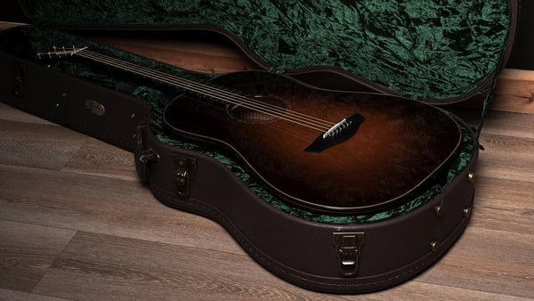 Acoustic guitar in a case on a wooden floor