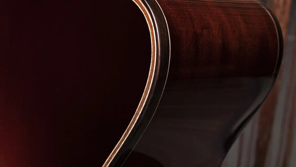 Close-up of a wooden acoustic guitar with a dark finish