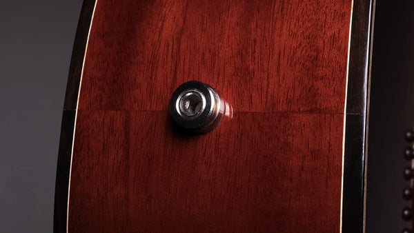 Close-up of a wooden guitar with a tuning peg on a dark background
