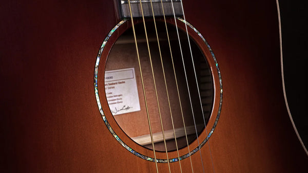 Close-up of an acoustic guitar's soundhole with a label on a dark background
